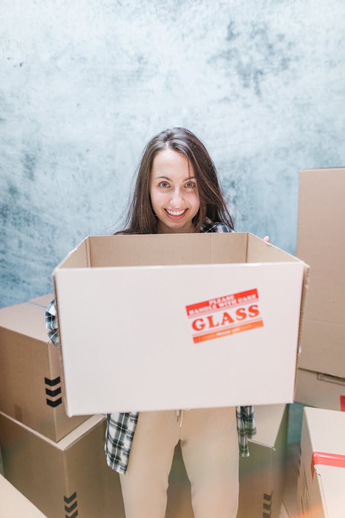 Girl in Pink Shirt Holding Brown Cardboard Box